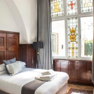 赫爾河畔京士頓的住宿－Endsleigh Park，一间卧室设有一张床和一个彩色玻璃窗