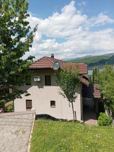 a white house with a tree in front of it at Villa Lake in Konjic