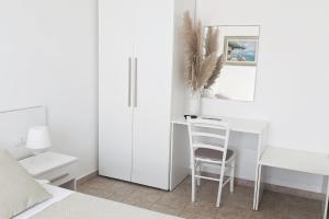 biała sypialnia z biurkiem i krzesłem w obiekcie IL MELOGRANO RESIDENCE MARZAMEMI w mieście Marzamemi