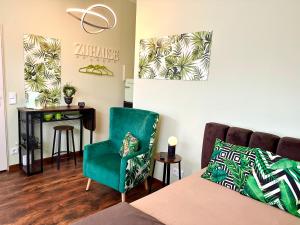 salon z zielonym krzesłem i biurkiem w obiekcie Apartelliment - smart übernachten in Köln w Kolonii