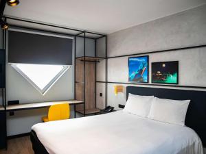 a hotel room with a bed and a window at Ibis Styles Abidjan Marcory in Abidjan