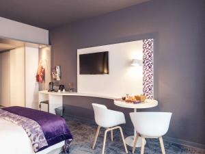 - une chambre avec un lit, une table et des chaises dans l'établissement Mercure La Roche Sur Yon, à La Roche-sur-Yon