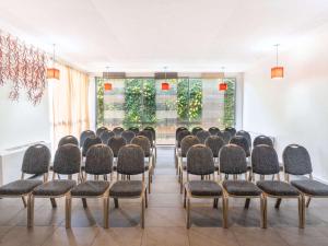 - une rangée de chaises dans une chambre avec fenêtres dans l'établissement Ibis Styles Abidjan Marcory, à Abidjan