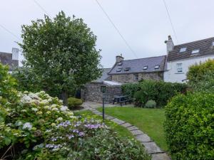 een tuin met een bank en bloemen in een tuin bij 3 Bed in Portpatrick 77308 in Portpatrick