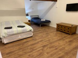 1 dormitorio con cama, mesa y TV en The Diary en Takeley