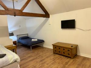 1 dormitorio con 1 cama y TV en la pared en The Diary en Takeley