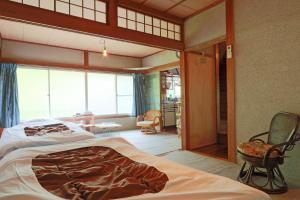 AkanoにあるCosmos Guesthouseのベッドルーム(大型ベッド1台付)、リビングルームが備わります。