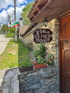 a sign on the side of a building with plants at Guest House Popov in Marchevo