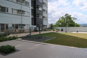 a large building with a grassy yard next to a building at Loft-Style Condo @ Avida Towers with Wifi in Davao City