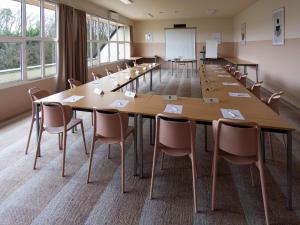 une grande salle de conférence avec une grande table et des chaises dans l'établissement ibis Styles Chinon, à Chinon