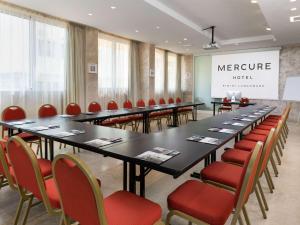 uma sala de reuniões com uma mesa longa e cadeiras em Mercure Rimini Lungomare em Rimini