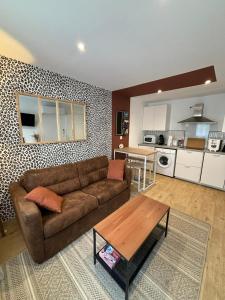 een woonkamer met een bank en een tafel bij Le gite des 3 mousquetaires in Amboise