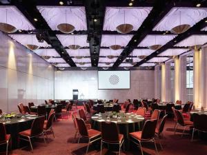 a conference room with tables and chairs and a screen at Pullman Melbourne On the Park in Melbourne