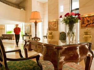 奧蘭的住宿－Royal Hotel Oran - MGallery Hotel Collection，大堂设有一张桌子,上面有花瓶