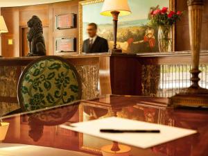 a desk with a mirror and a man in a painting at Royal Hotel Oran - MGallery Hotel Collection in Oran