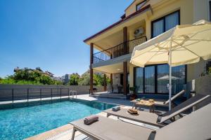 a villa with a swimming pool and a house at Villa Sorrento in Fethiye