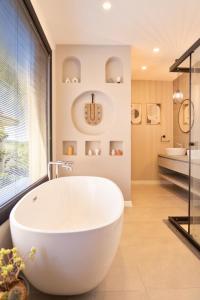 a bathroom with a large white tub in front of a window at Villa Sorrento in Fethiye +52 photos