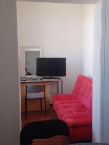 sala de estar con sofá rojo y escritorio en Toimisto-Majoitus A, en Kokkola