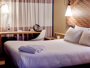 um quarto de hotel com uma cama e uma secretária em ibis Irkutsk Center em Irkutsk