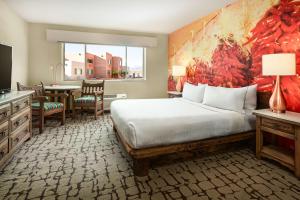 Cet appartement comprend une chambre avec un lit, une cuisine et une table. dans l'établissement Hilton Tapestry Collection, Hotel Don Fernando De Taos, à Taos