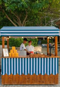 two men are standing at a food cart at Marsa Malaz Kempinski, The Pearl in Doha