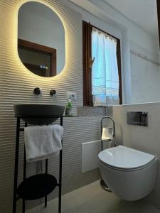 un bagno con lavandino, water e specchio di casa a pochi minuti dalla spiaggia di vignola a Vignola Mare