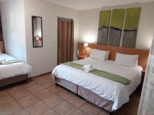una habitación de hotel con una gran cama blanca. en 24 Onvrey Guest House, en Boksburg