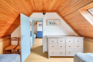 een slaapkamer op zolder met een wit dressoir en een houten plafond bij Plage et decouverte de la Bretagne in Plobannalec-Lesconil