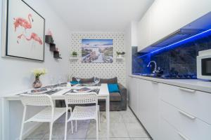 jadalnia ze stołem i krzesłami oraz kuchnia w obiekcie MGR Pokoje w samym Centrum Warszawy by Metro Rondo ONZ - SUPER Bed Year23 w Warszawie