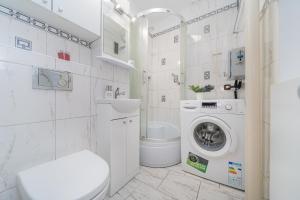 biała łazienka z pralką i pralką w obiekcie MGR Pokoje w samym Centrum Warszawy by Metro Rondo ONZ - SUPER Bed Year23 w Warszawie