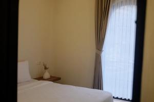 a bedroom with two beds and a window at Sora Boutique Stay in Ciwidey