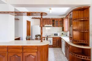 una cocina con armarios de madera y electrodomésticos blancos en Maya Apartments, en Mindelo