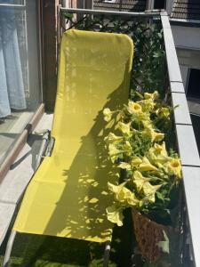 a planter filled with yellow flowers on a porch at MARINY in Spa