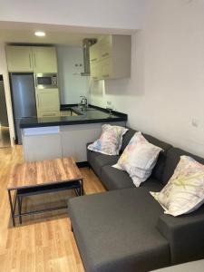 a living room with a couch and a table and a kitchen at Ático dos dormitorios en el centro de Córdoba in Córdoba +11 photos