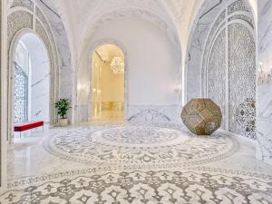 une grande chambre avec un sol en marbre et une grande chambre avec un bâtiment dans l'établissement Raffles Doha, à Doha
