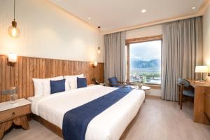 a hotel room with a large bed and a window at The Highland Ladakh in Leh