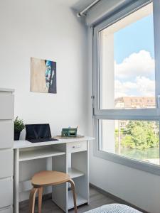een bureau in een kamer met een raam bij Au 4 le long du canal avec Parking in Dijon