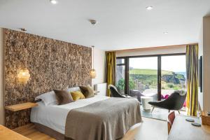 a hotel room with a bed and a large window at Bedruthan Hotel & Spa in Newquay +56 photos