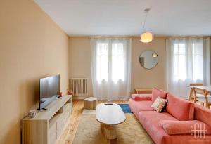 a living room with a red couch and a tv at L'oeillet - Place Plumereau in Tours