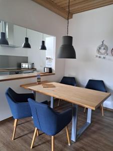 a kitchen with a wooden table and blue chairs at Villa Max in Berchtesgaden