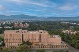 an aerial view of a building with mountains in the background at Vivanta Jamshedpur, Golmuri in Jamshedpur