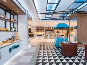 uma cozinha de restaurante com piso em xadrez em ibis Styles Manila Araneta City em Manila