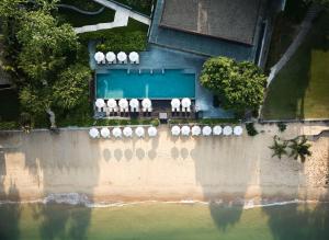 eine Luftansicht auf einen Strand mit weißen Stühlen und dem Wasser in der Unterkunft Andaz Pattaya Jomtien Beach, a Concept by Hyatt in Na Jomtien