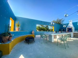 een blauw ommuurde patio met een tafel en stoelen bij Cueva Ventica in Benamaurel
