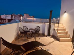 a patio with chairs and a table on a roof at Karibu Serenity in Almendralejo
