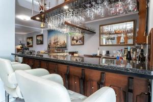 a bar with white chairs and a long counter at Vale de Paraíso Pechão in Olhão