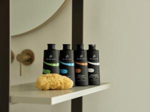 a shelf with four bottles and a cookie on it at Andronis Boutique Hotel in Oia