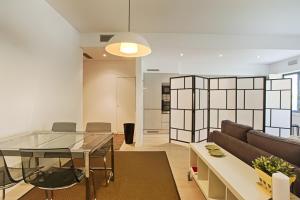 un soggiorno con tavolo in vetro e divano di BmyGuest - Prestige Palace Apartment a Lisbona