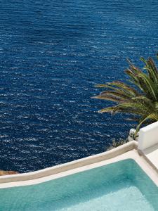 a swimming pool with the ocean in the background at Andronis Boutique Hotel in Oia
