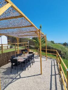 a patio with a table and chairs under a wooden structure at Superbe bas de Villa au calme in Cagnes-sur-Mer